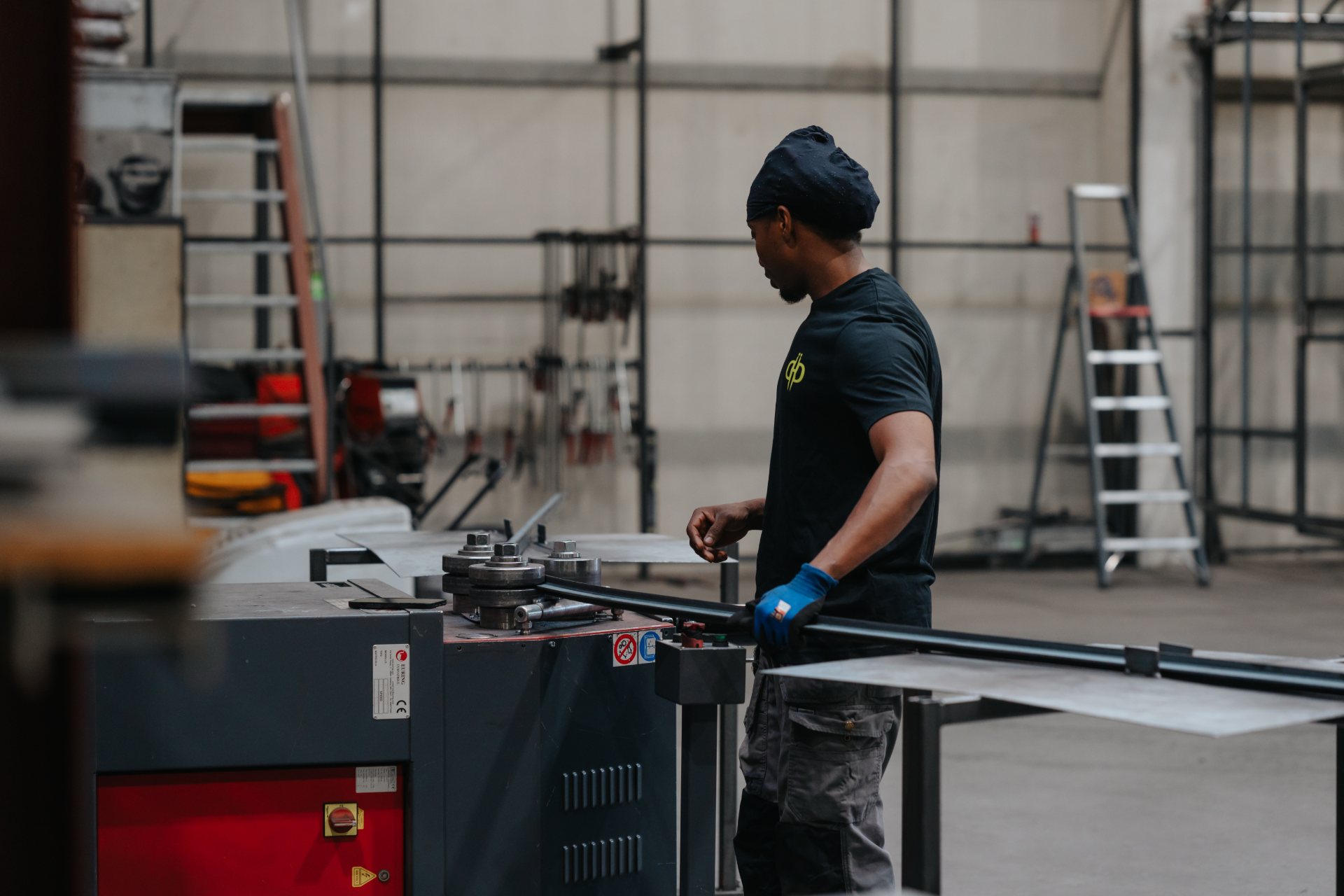 Vakman van De Nieuwe Smid bewerkt stalen profielen voor een serre op maat in het atelier in Lier
