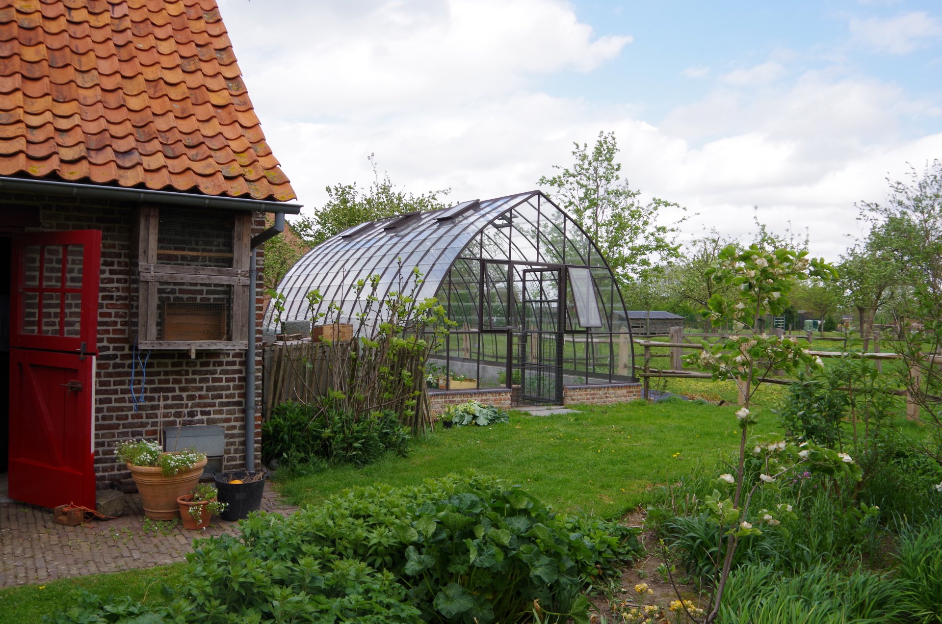 Stalen serre vrijstaand in de tuin in Nevele, op maat gemaakt door De Nieuwe Smid